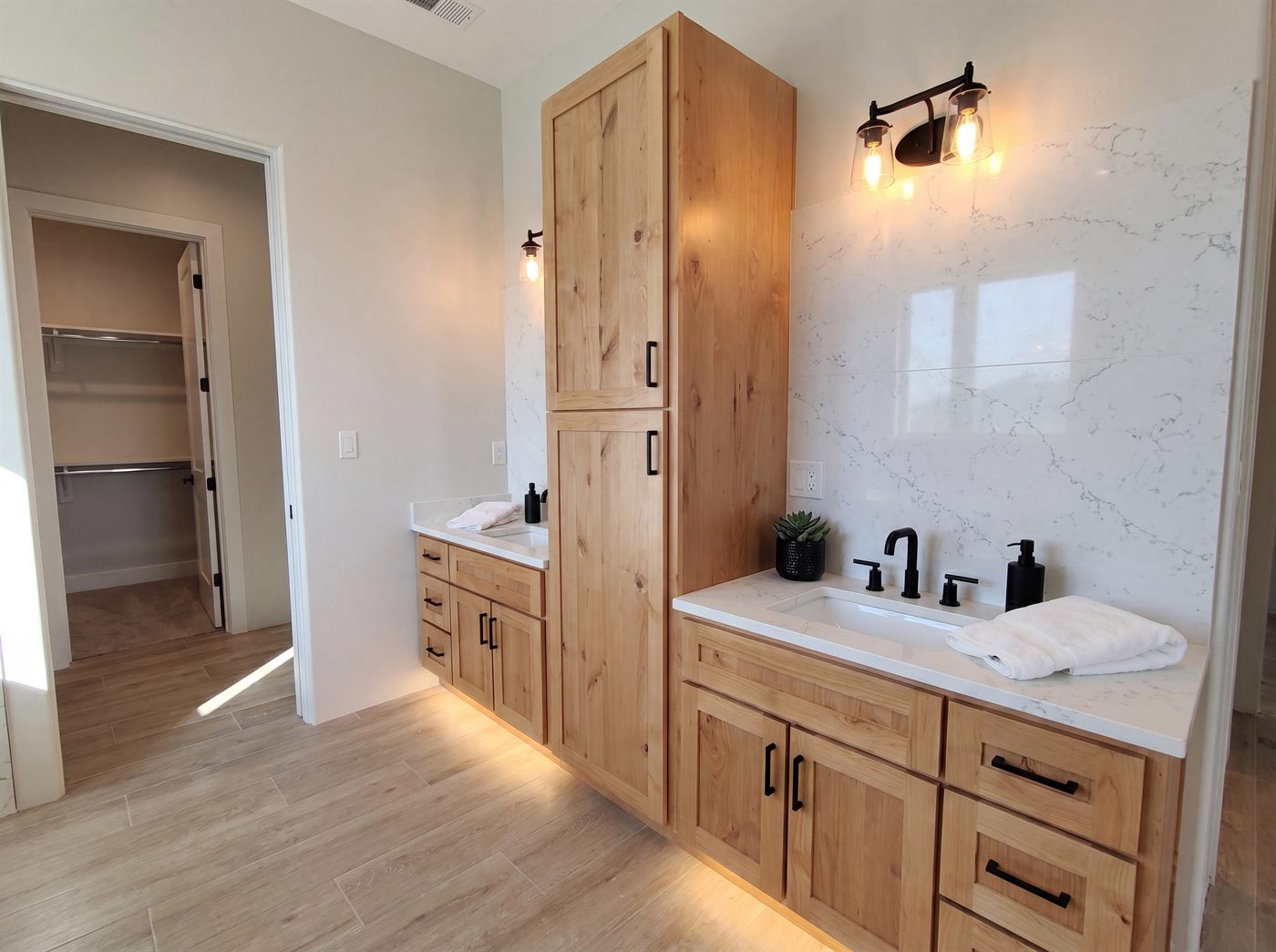 Modern farmhouse master bathroom with double maple vanities, quartz counters and walk-in closet